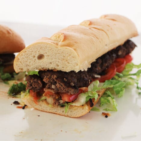 Foot long burger with some already served showing the cross-section of the burger.