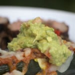 Guacamole served on top of a plated item.