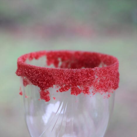 A disposable glass with a bright red jello crystal rim.