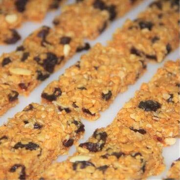 Several fully baked muesli bars sliced and resting on baking parchment.