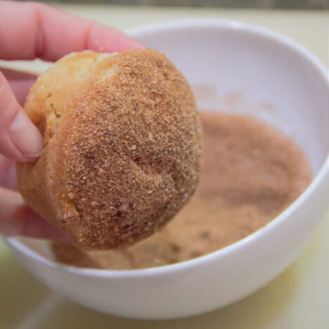 An apple muffing having just been dipped into the cinnamon sugar.