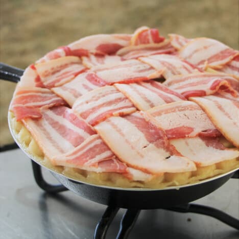 A raw bacon lattice topped apple pie.