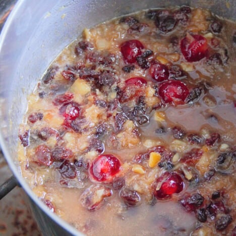 The fruit, butter, and sugar simmering in a pot.