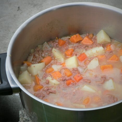 Close up of corned beef stew simmering in a stainless pot.