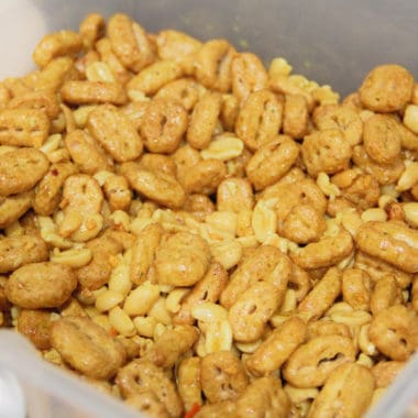 Close up of finished nuts and bolts mix, peanuts and cereal coated in savory flavored oil.