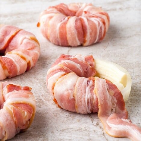 Bacon, pineapple, and mozzarella donuts sitting on a whiteboard in various stages of constuiction.