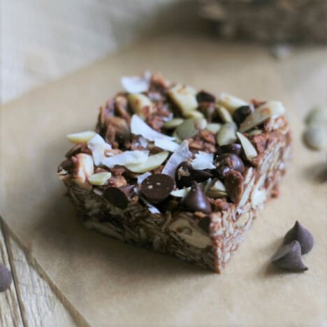Looking down on a single no-bake energy bar, covered in chocolate chips and coconut flakes.