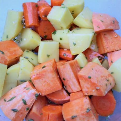 Raw diced potatoes and sweet potatoes in herbs.