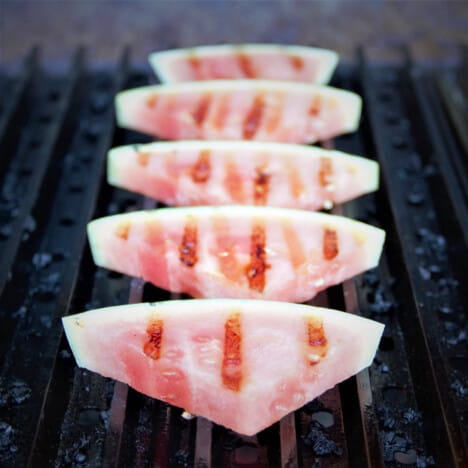 Wedges of watermelon cooking on the grill.