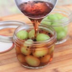 A jar of grapes having the prepared pickling liquid poured over them.