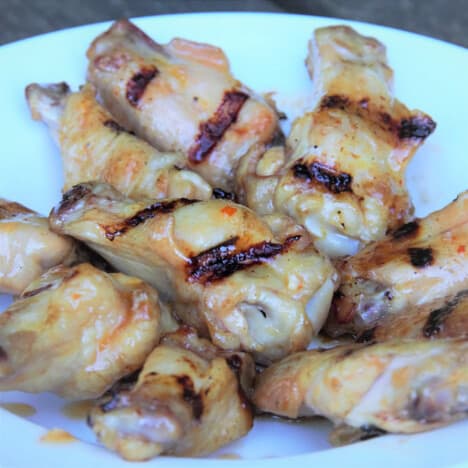 Smoked sweet chili grilled chicken wings on a white plate.