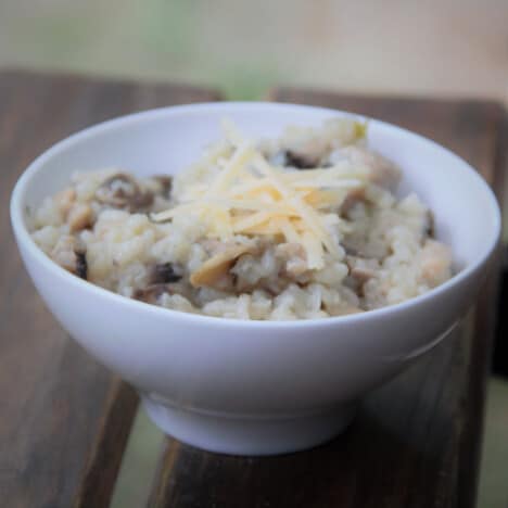 A white bowl holds a serving of the chicken and mushroom risotto.