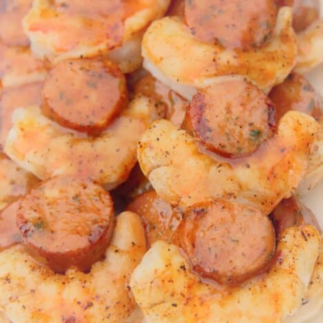 Close up look at finished shrimp and smoked sausage with a moist looking glaze.