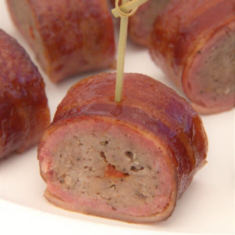 A close up on a slice of the bacon-wrapped sausage.