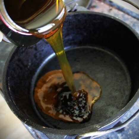 Golden syrup being poured into a Dutch oven.