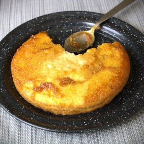A black camp plate with an inverted breakfast pancake pudding on it.