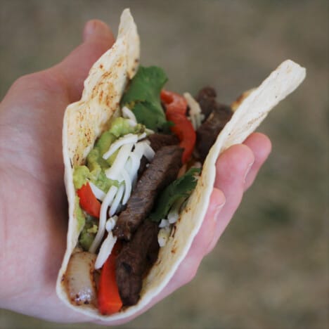 A made fajita being held in a hand.