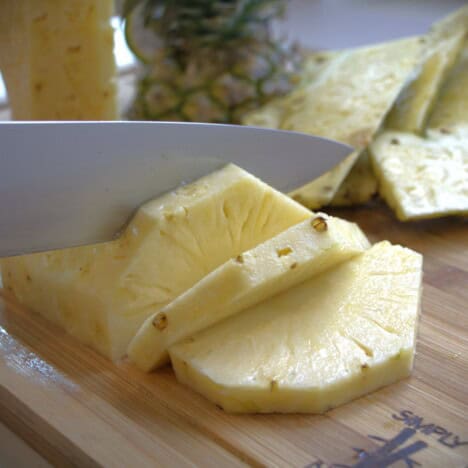 Half a fresh pineapple being sliced.