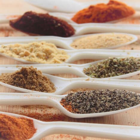 Looking over a range of white teaspoons filled with a variety of spices.