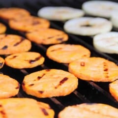 Slices of grilled sweet potato and apples are on the grill.