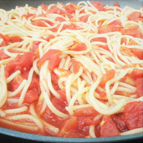 A close up of spaghetti noodles with camp tomato sauce.