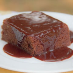 Close up of a chocolate dessert cake showing the chocolate sauce running down the sides.