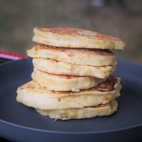 An even stack of corn fritters on a serving plate.