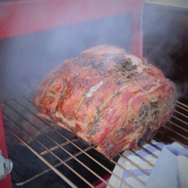 A smoked prime rib roast being checked in the smoker.
