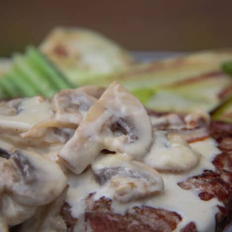 Close up of the mushroom sauce on a steak showing the slices of mushroom.