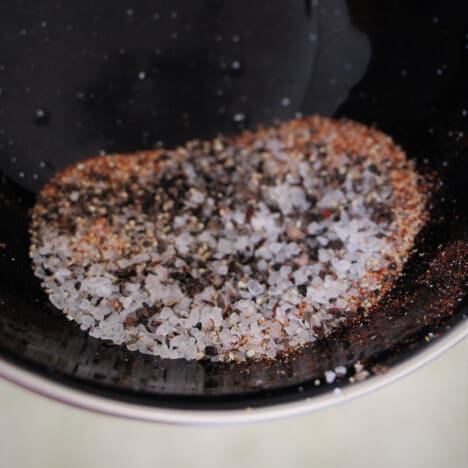 A large grained rub being displayed in a black camp bowl.