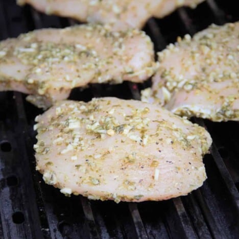 Grillgrates with the pesto marinated chicken breasts having just been added to the grill.