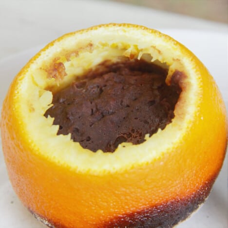Looking into a hallowed-out orange filled with chocolate cake batter.