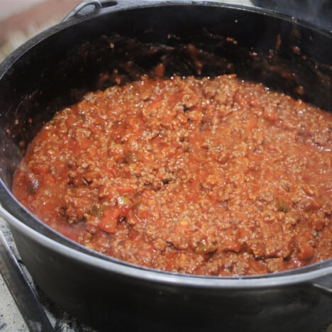A Dutch oven filled with cooked sloppy joe beef sauce.