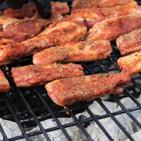 Ribs sitting offset to the charcoal heat in a grill.