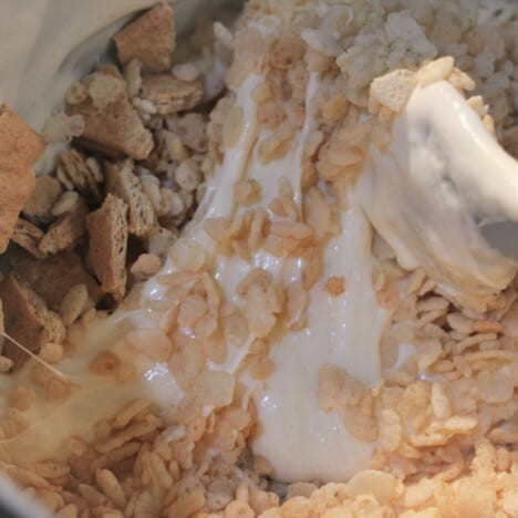 The hot marshmallow mixture with the Rice Krispies and broken Graham crackers being added.