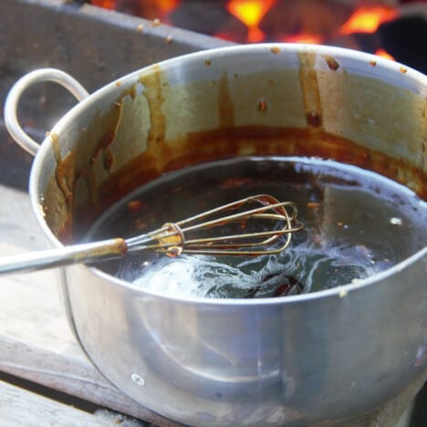 A stainless steel pot holds the drumette sauce with a whisk inside.