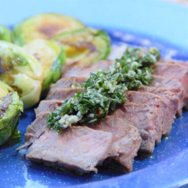 Sliced beef steak topped with the chimichurri sauce