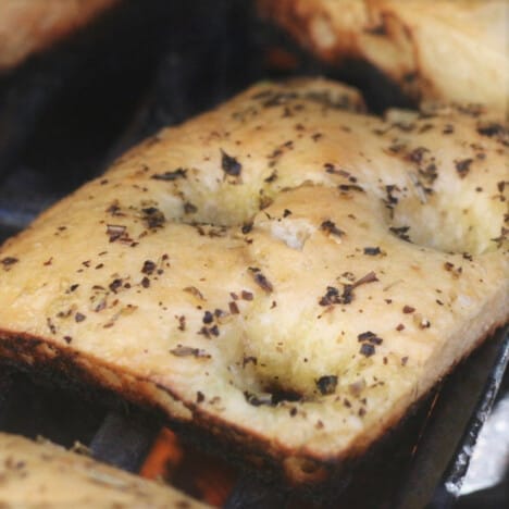A close up of a square of focaccia bread on the grill.