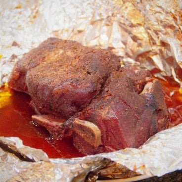 A smoked pork shoulder butt resting in foil.