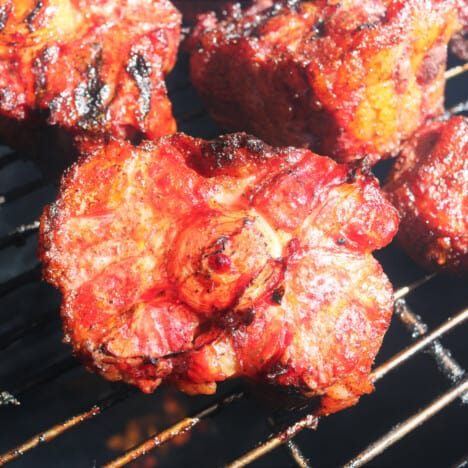 Smoked oxtail sitting on a grill grate in a smoker.