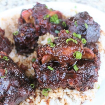 Braised oxtail served over rice garnished with green onions.