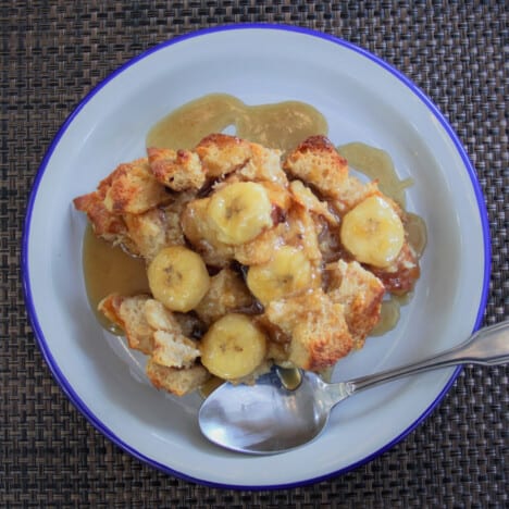 Arial view of a serving of Bananas Foster Bread Pudding in a shallow white bowl.