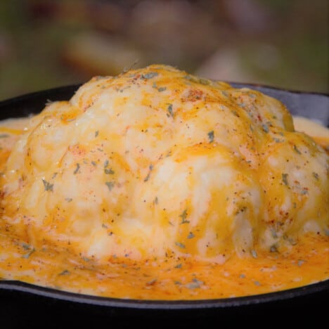 A head of cauliflower covered in melted cheese and bechamel sauce.