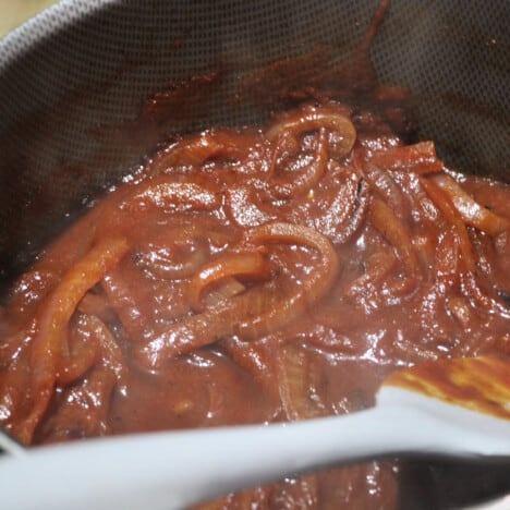 Looking into a pot filled with caramelized onion sauce.
