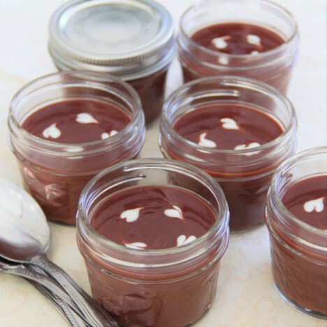 A spread of completed chocolate cups with one in the back with the lid on it.