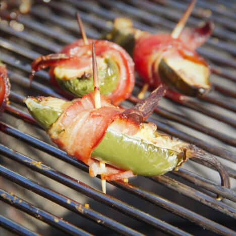 Close-up of a bacon wrapped jalapeño pepper poppers on a grill.