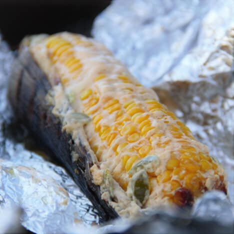 Close up of Mexican street corn just before removing from its foil wrap.