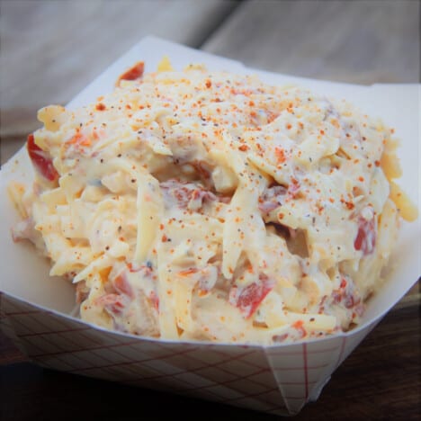 A pile of pimento cheese spread in a paper boat.