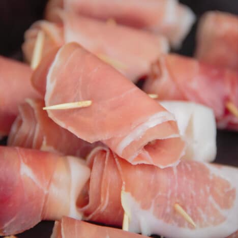 Pile of prepared prosciutto-wrapped scallops awaiting to be grilled.