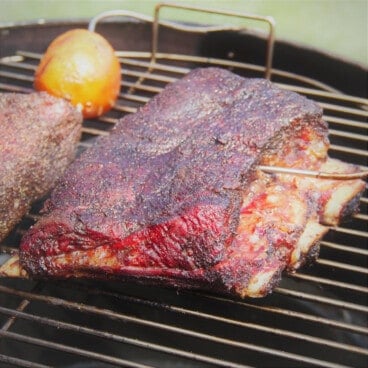 Smoked coffee beef ribs on a grill with a deep mahogany color.